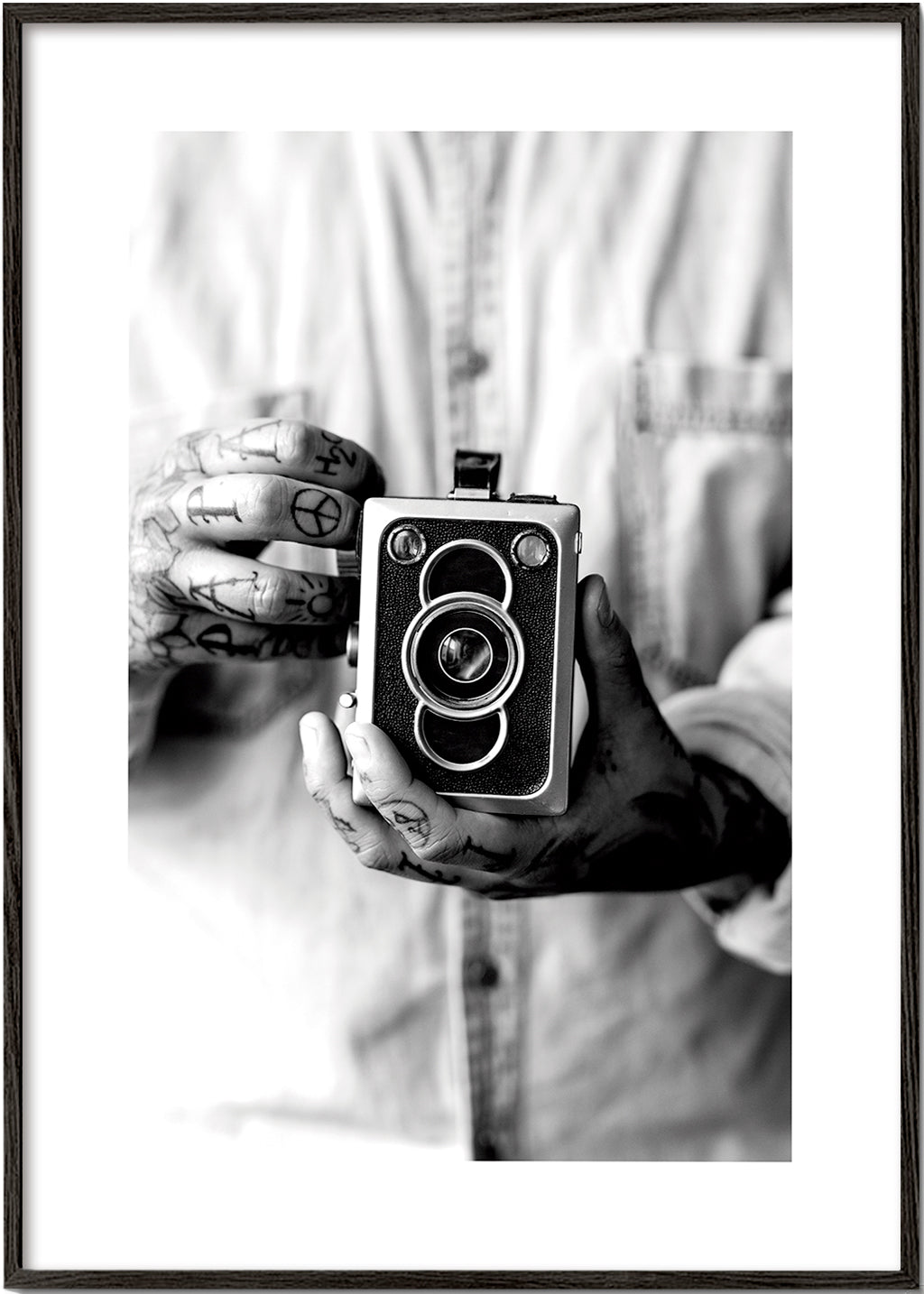 Vintage print: oude camera in getatoeëerde handen