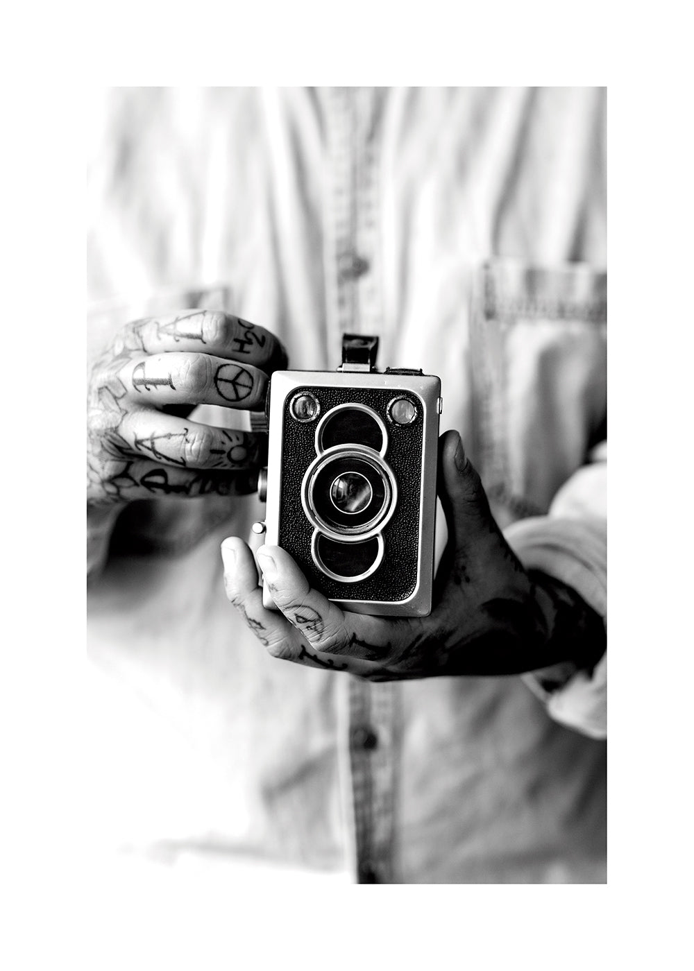 Vintage print: oude camera in getatoeëerde handen