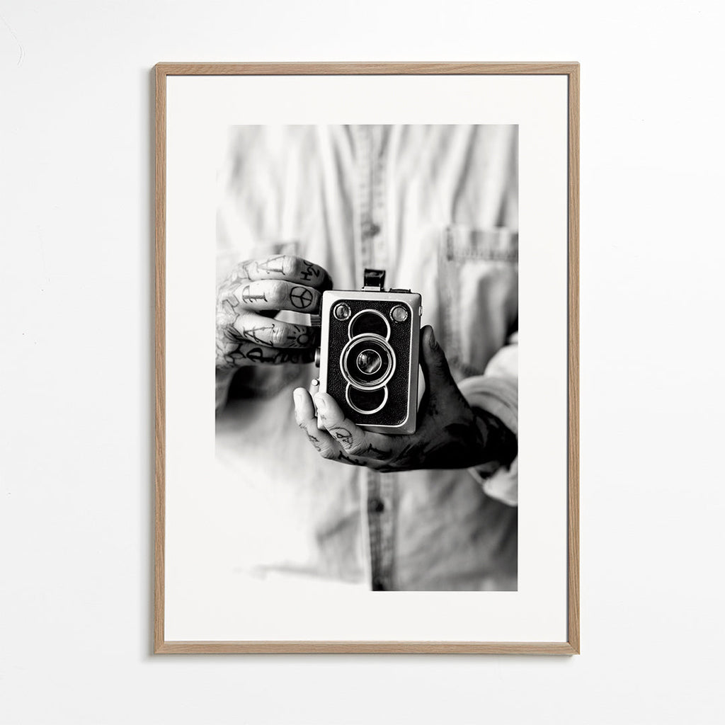Vintage print: oude camera in getatoeëerde handen