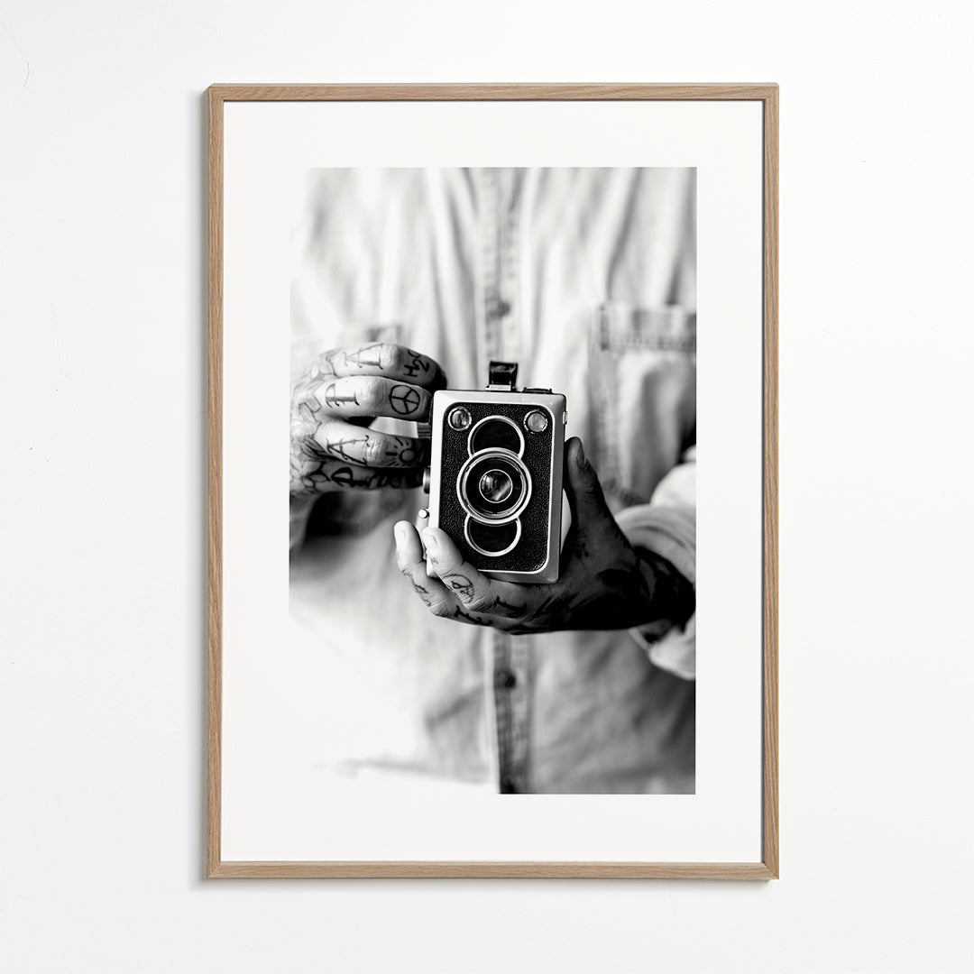 Vintage print: oude camera in getatoeëerde handen