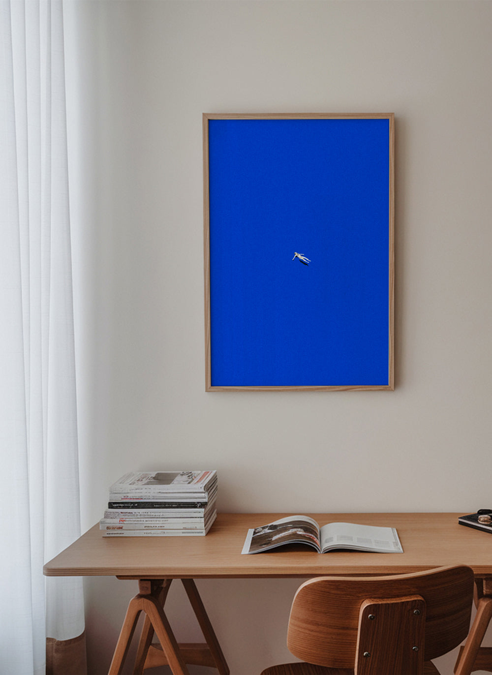 Minimalistisch kunstwerk met drijvend figuur tegen blauwe lucht