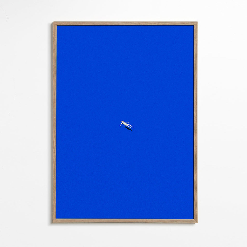 Minimalistisch kunstwerk met drijvend figuur tegen blauwe lucht