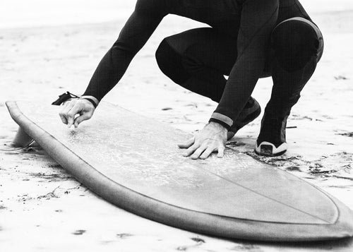 Sport kunst: surfer die zijn board klaarmaakt