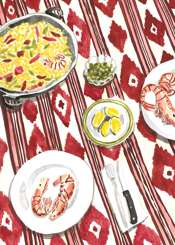 Küchenkunst: Paella und Garnelen auf gemustertem Tuch