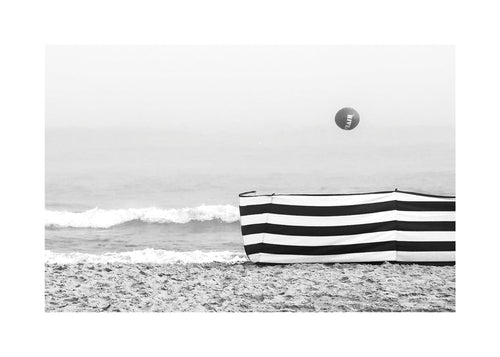 Strandlandschap met gestreept windscherm