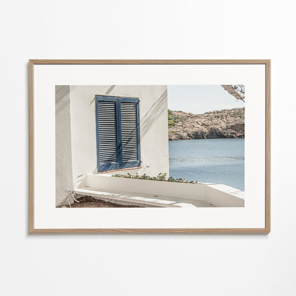 Kustlandschap met blauw luik en rotsachtige baai