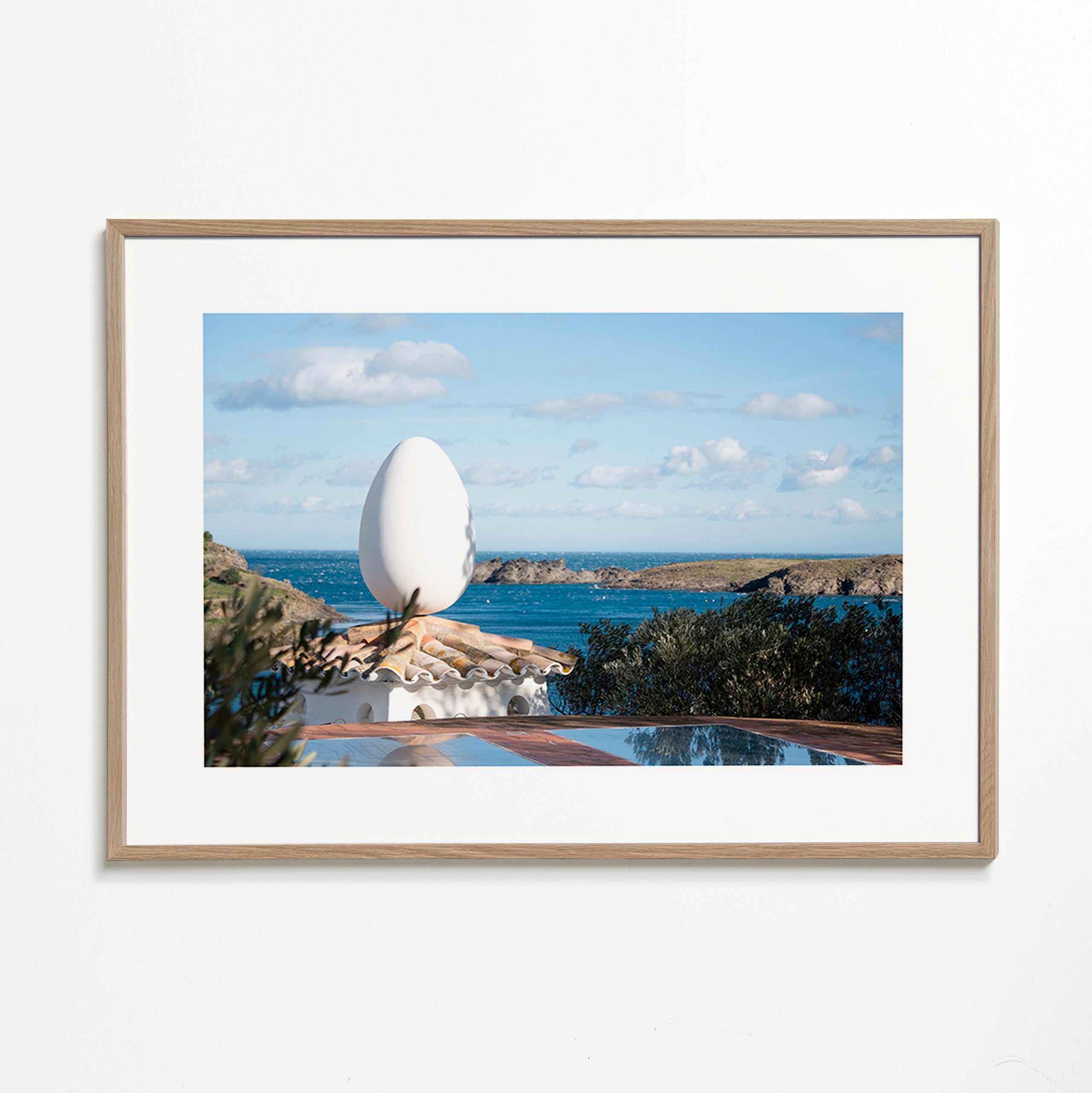 Art de paysage avec sculpture ovoïde en bord de mer