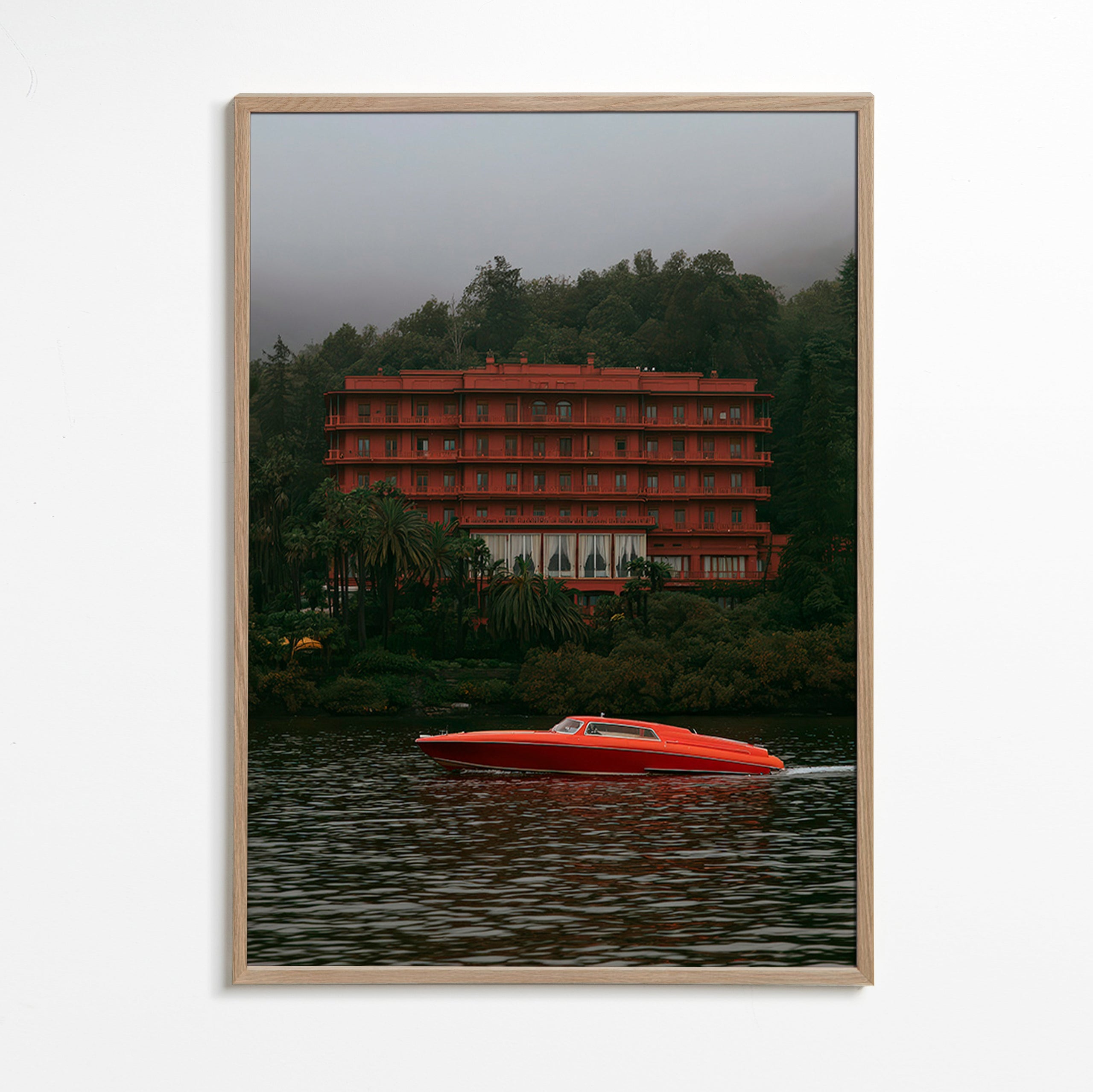 Landschapsschilderij met rood hotel en speedboot